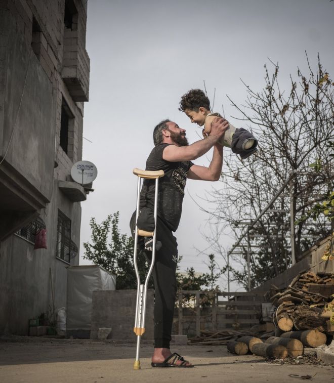 H φωτογραφία της χρονιάς – Η εικόνα-γροθιά στο στομάχι πατέρα και γιου με φόντο τον πόλεμο στη Συρία
